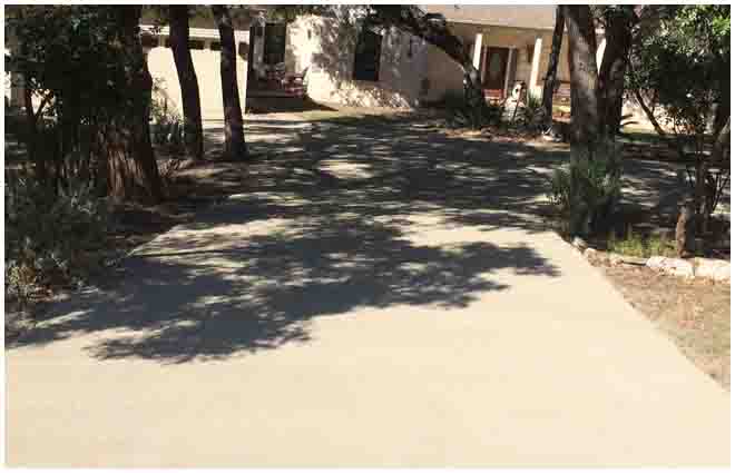 Completed chip-seal driveway beneath trees