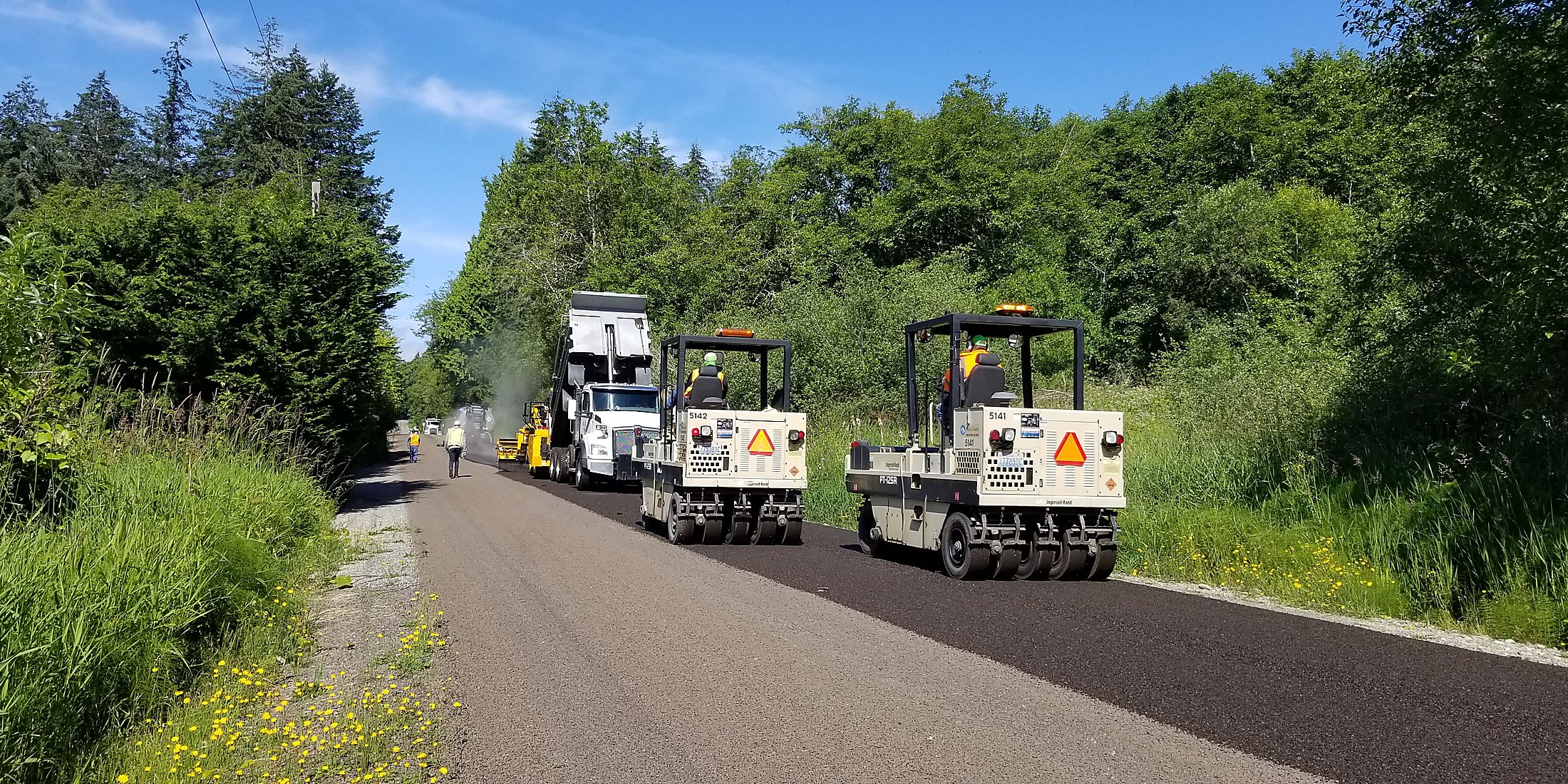 Freshly paved road and paving equipment